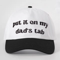 Detail of contrast baseball cap with 'put it on my dad's tab' embroidery and black brim - White and Black Splicing