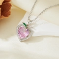 Macro shot of silver heart necklace with pink gem and green leaf detail on silk - Silver Pink Zircon Heart Necklace (T021)