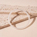 Primer plano de pulsera de acrílico blanco translúcido con degradado sobre travertino - Brazalete-Color Plata