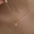 Detail of s925 silver necklace with gold plating and oval zircon pendant on a model - Gold