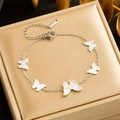 Detail of silver stainless steel butterfly bracelet on a luxury gold gift box lid - B1375 Silver