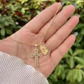 Dettaglio collana dorata con croce di zirconi e ciondolo con rilievo di rosa vintage - Oro