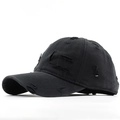 Detailed close-up of distressed ripped holes and worn edges on black cotton baseball cap - Black