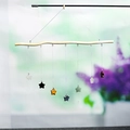 Handmade wind chime with seven natural star-shaped crystals hanging from a wooden stick - Star Style