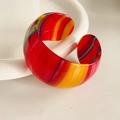 Macro detail of wide open cuff bracelet with vibrant multi-color striped resin pattern - Multi-color Striped