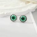 Macro shot of green evil eye stud earrings with detailed pupil and silver metal edge - Silver Green Glitter Eye