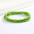 Close-up of emerald green layered glass bead waist chain on white satin background - Emerald Green