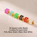 Macro view of square gold-plated letter beads with multi-color enamel inlay details - Letter F / Red