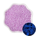 Luminous light purple glass seed beads in white bowl showing glow-in-the-dark blue effect - Red Purple