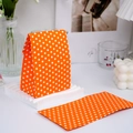 Orange polka dot mini paper gift bag shown in folded and flat states on a white table - Orange with White Dots