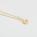 Minimalist gold necklace with a round U-letter pendant and sparkling crystal details - Letter U