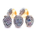 Detalle de cinco anillos dorados con racimos de cristales de colores irregulares - Multicolor