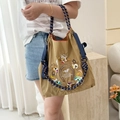 Detail of khaki nylon bag featuring intricate carousel embroidery and blue drawstring rope - Khaki Horse Racing (No Strap)