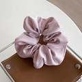 Elegant soft pink satin scrunchie with smooth silk texture and lustrous folds - Pink