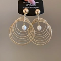 Detalle macro de pendientes de aro dorados multicapa con perla blanca y perno de bola - Dorado
