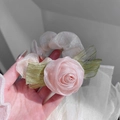 Close-up of pink fabric rose and green leaf detail on a sheer tulle hair scrunchie - Pink