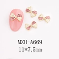 Macro view of gold bow-knot nail art charms with pink rhinestones for DIY decoration - Vibrant 3D Bow (A669)