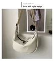 Detail of hobo bag in cream white with a black fluffy pompom charm and zipper closure - Soot Sprite Charm Style / Off White