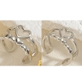 Dettaglio dell'anello aperto a cuore d'argento con centro cavo e piccoli cuori laterali - Clip per orecchio a cuore in platino