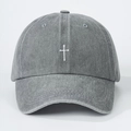 Close-up of a vintage grey washed denim baseball cap with white cross embroidery - Gray
