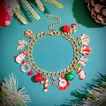 Detail of festive gold bracelet with Santa, snowflake, and bell charms on pine background - Multi-Element Gold Style (7477)