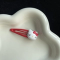 Cute red Hello Kitty hair clip for girls on a heart-shaped white ceramic tray - Kt Red Bb Clip
