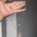 Detail of four-layered gold necklace with green beads, cross, and engraved coin pendant - Hollow Flower Cross Multilayer Turquoise Necklace