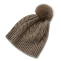 Textura de punto detallada y pompón suave en un gorro de invierno color marrón café - Camel Oscuro