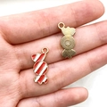 Enamel candy shaped metal pendants in red and white stripes held on palm - Red White Candy