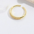 Detail van een goudkleurige verstelbare druppelring bezet met glanzende zirkoon - Witte Zirconia (Breed)