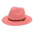 Close-up of pink woven straw Panama hat with brown leather band and gold buckle detail - Pink