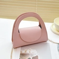 Pink PU leather handbag with golden chain strap on a minimalist soft-light background - Pink