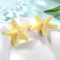 Detail of two yellow resin starfish charms with white texture on a blue water wave surface - Small / Yellow