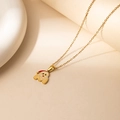 Detailed close-up of a gold stainless steel necklace with a Santa Claus pendant - Santa Letter M