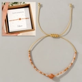 Makro-Detail des handgewebten goldenen Armbands mit Citrin-Stein und November-Geschenkkarte - November Geschenkbox Plus/Orange/Citrin