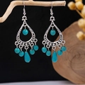 Macro shot of Bohemian turquoise earrings with vintage silver tassels hanging on a branch - E5775-12/Multi-Bead Pendant Hollow Turquoise