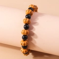 Beaded Halloween bracelet featuring orange pumpkin and black beads on a display stand - Pumpkin Style / Orange