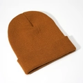 Close-up of fine knit texture and classic cuff design on a brown acrylic beanie hat - Caramel