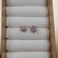 Elegant four-prong natural purple amethyst stud earrings with gold finish on cream stand - Ruby