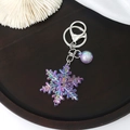 Macro view of colorful acrylic snowflake keychain with iridescent bubble ball and lobster clasp - Purple