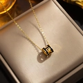 Gold titanium necklace featuring a black and gold cylindrical H-pendant on a metal box - 8803 Gold Black