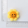 Yellow crochet sunflower keychain with smiley face and ruler showing 6x6cm size - Rounded Smiley Sunflower