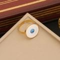 Detail eines verstellbaren Goldrings mit weißem Emaille-Auge auf einem Schmuckständer - Stil 4: Ring