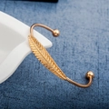 Elegante bracciale rigido piuma d'oro con dettagli a foglia e sfere metalliche lisce - Oro (8897)