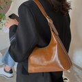 Brown faux leather hobo shoulder bag with gold hardware worn with a black blazer - Brown