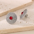 Detail of silver round sunburst stud earrings with red center stone and white crystals - Steel Red