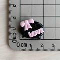 Close-up of black oval resin charm with pink 3D bow and LOVE text beside a ruler - Black Base Pink LOVE