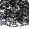 Macro detail of mixed black and grey glass beads with golden accents for DIY jewelry - Dark Blue Series