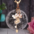 Dettaglio portachiavi con pompon grigio, cuore inciso I love you e anello in metallo dorato - Cuore di Legno + Pompon Grigio