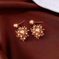 Detalle macro de pendientes de perlas bañados en oro de 18K con diseño de fuegos artificiales - Oro Champaña (Bañado en Oro de 18K/Pin de Plata 925)